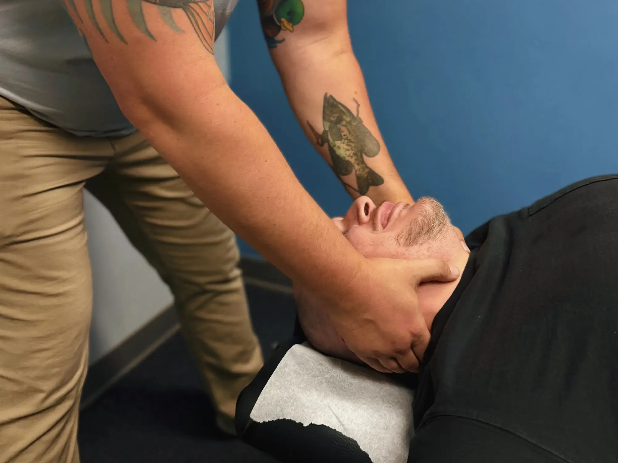 Person on a therapy table receiving a neck adjustment