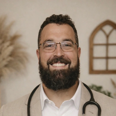 Dr. Jake Harris wearing a light‑colored blazer over a collared shirt
